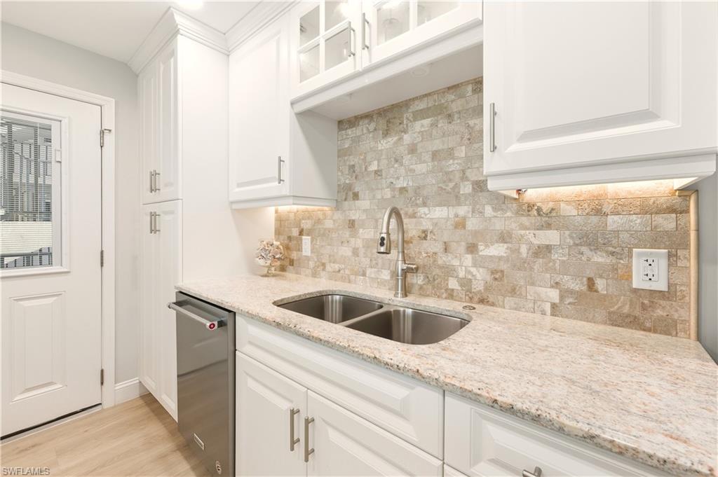 Kitchen featuring white cabinets, glass insert cabinets, and dishwasher