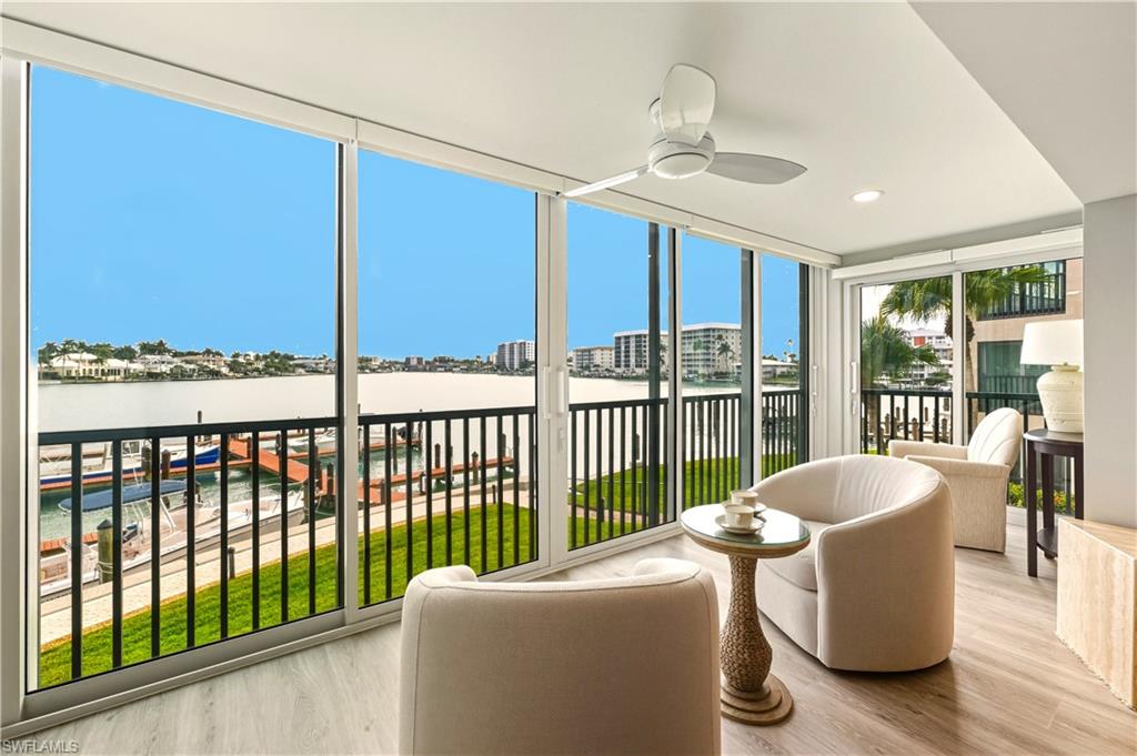 Sunroom with expansive windows, a water view, recessed lighting, and vinyl floors