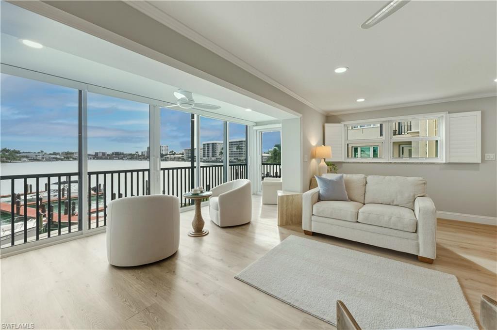 Living room with crown molding, vinyl floors, recessed lighting, and a water view