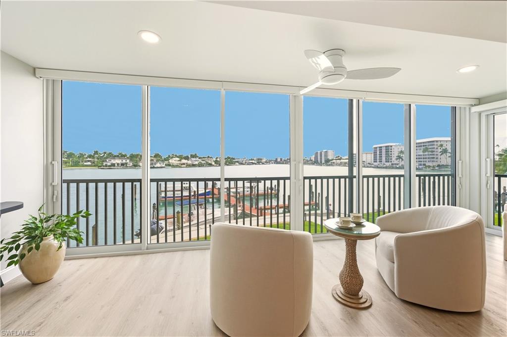 Sunroom with vinyl finished floors, expansive windows, recessed lighting, and a water view
