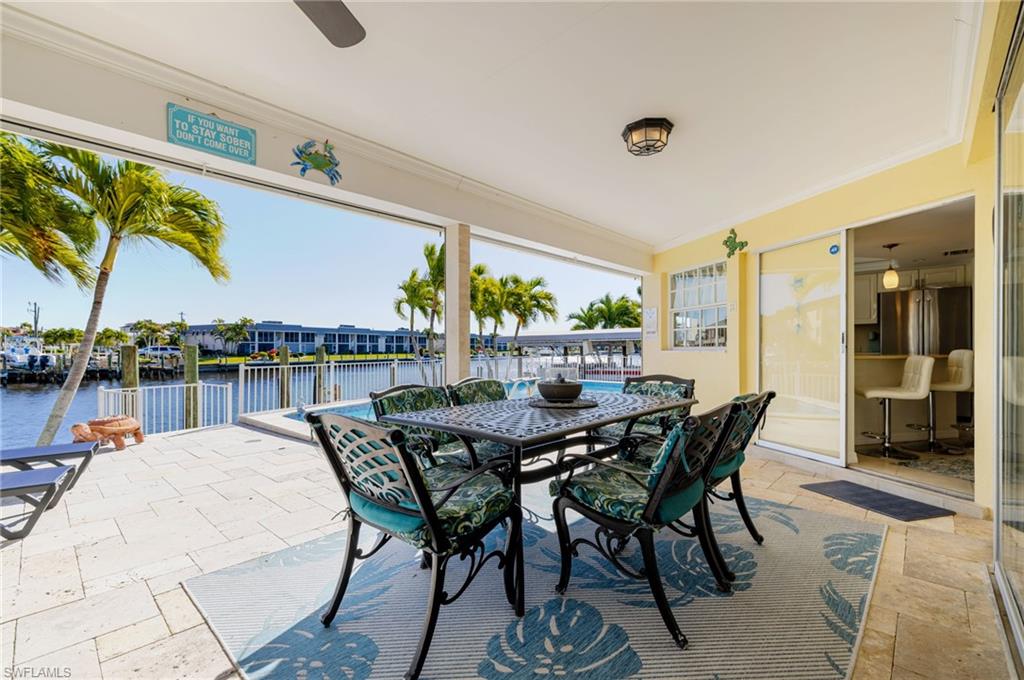 View of patio featuring outdoor dining area, a water view, and ceiling fan