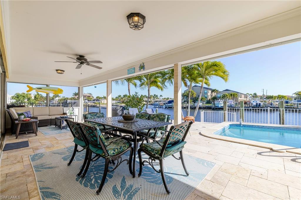 View of patio featuring an outdoor living space, a water view, ceiling fan, an outdoor pool, and outdoor dining area