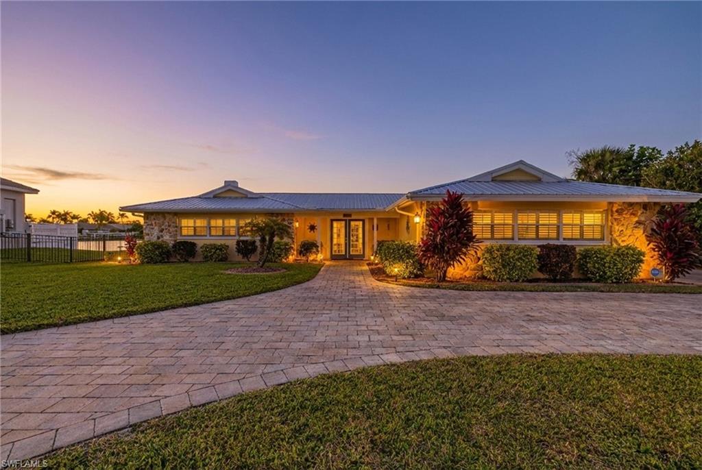 View of front of house with a front yard, french doors, and a metal roof