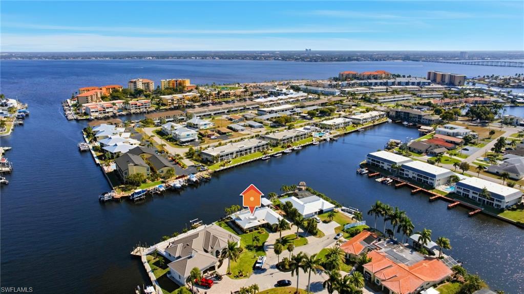 Aerial view of property and surrounding area with a nearby body of water