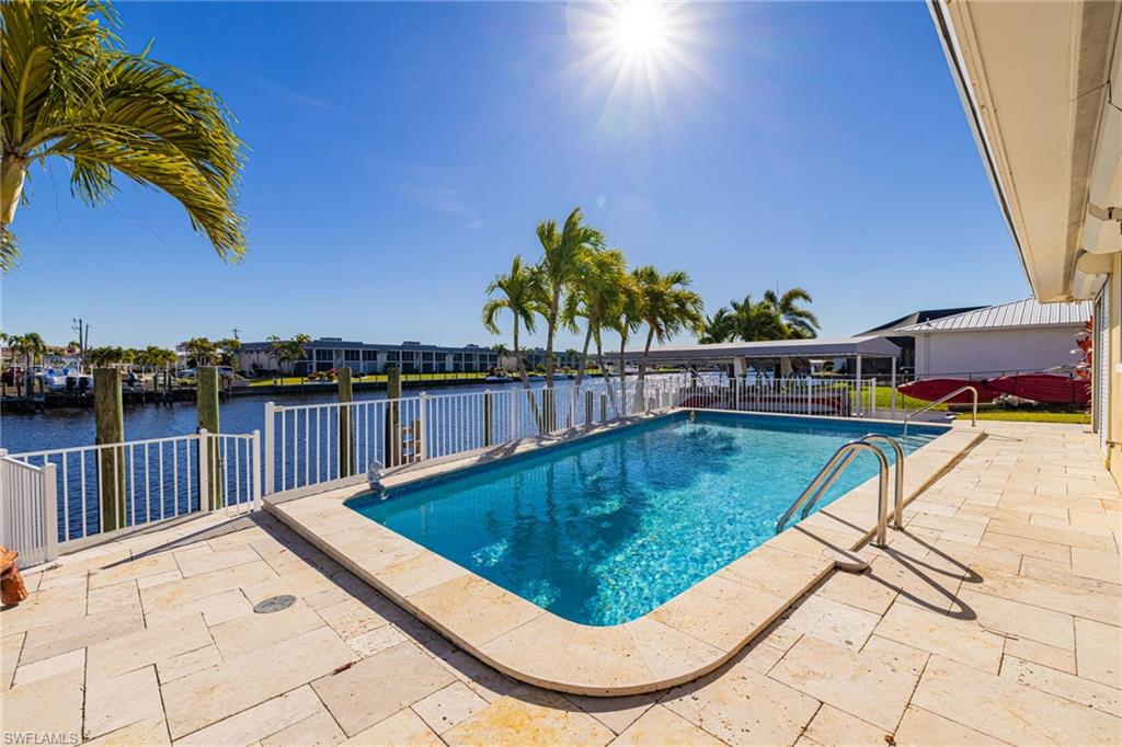 View of swimming pool with a patio area and a water view