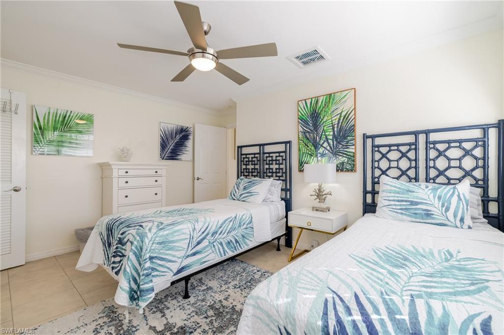 Bedroom with ornamental molding, ceiling fan, and tile patterned floors
