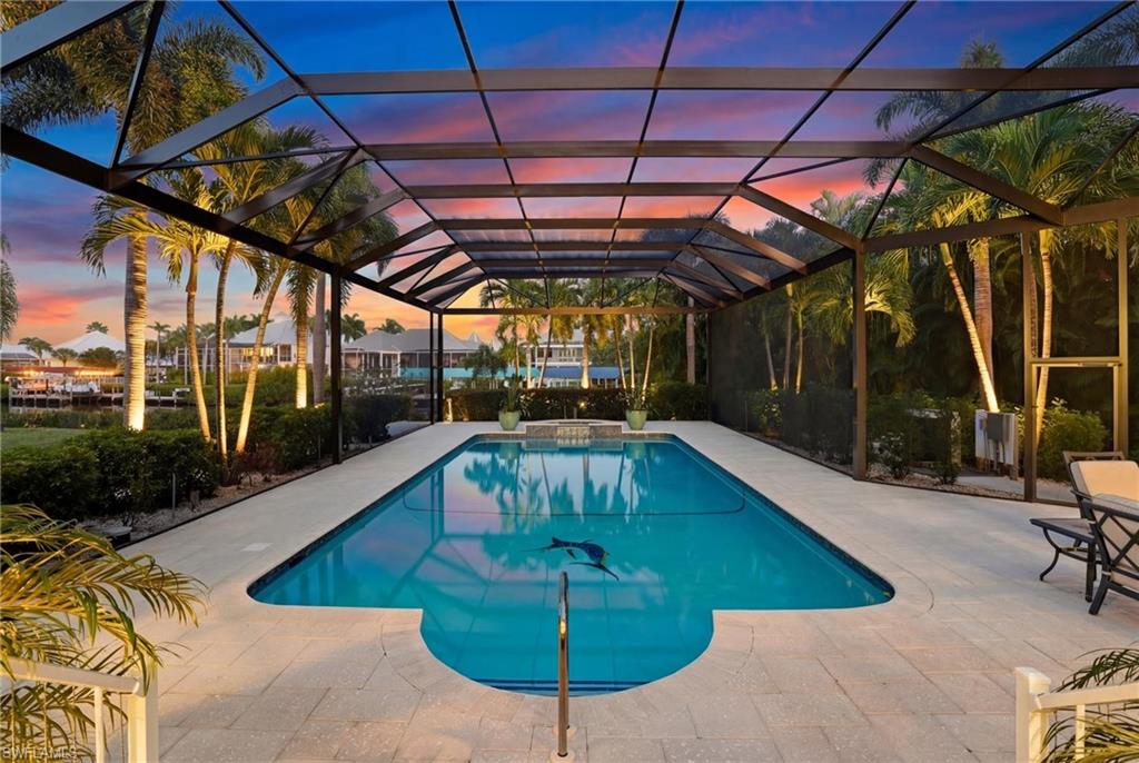 Integrated pool / hot tub featuring glass enclosure, a patio, and a sunroom