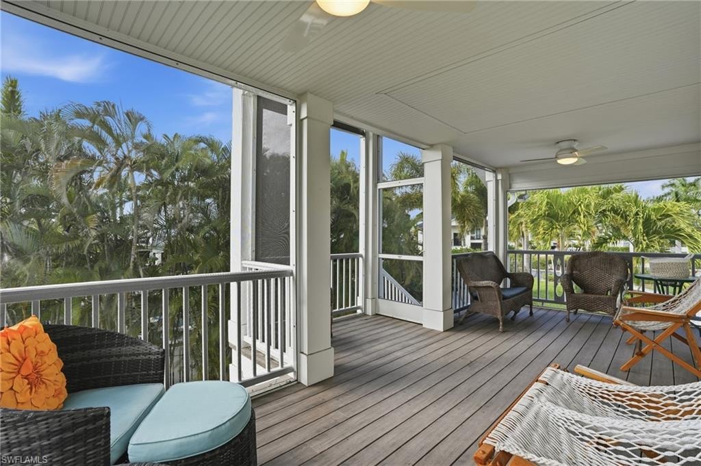 Sunroom / solarium featuring a ceiling fan, plenty of natural light, and a deck