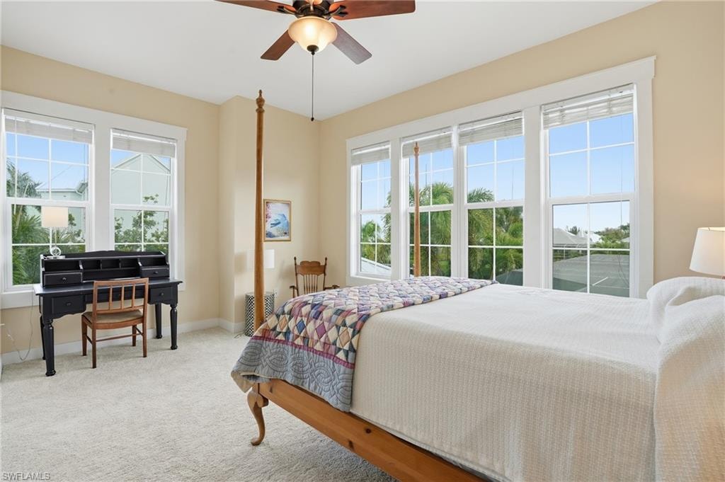 Carpeted bedroom featuring baseboards and ceiling fan