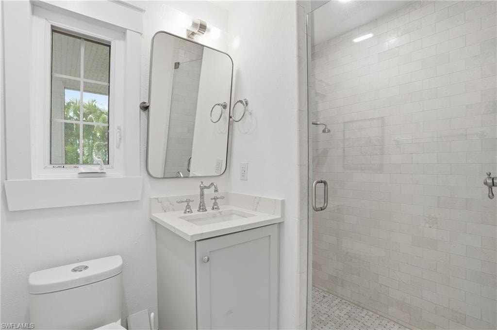 Full bath with a shower stall and vanity
