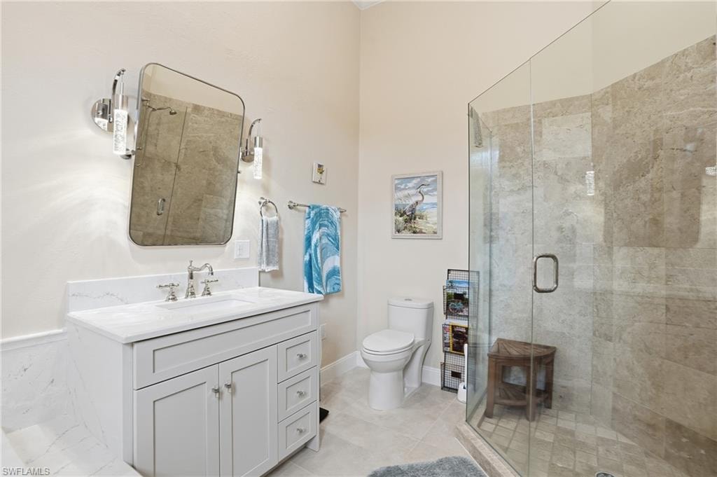 Bathroom with vanity, a shower stall, and light tile patterned floors