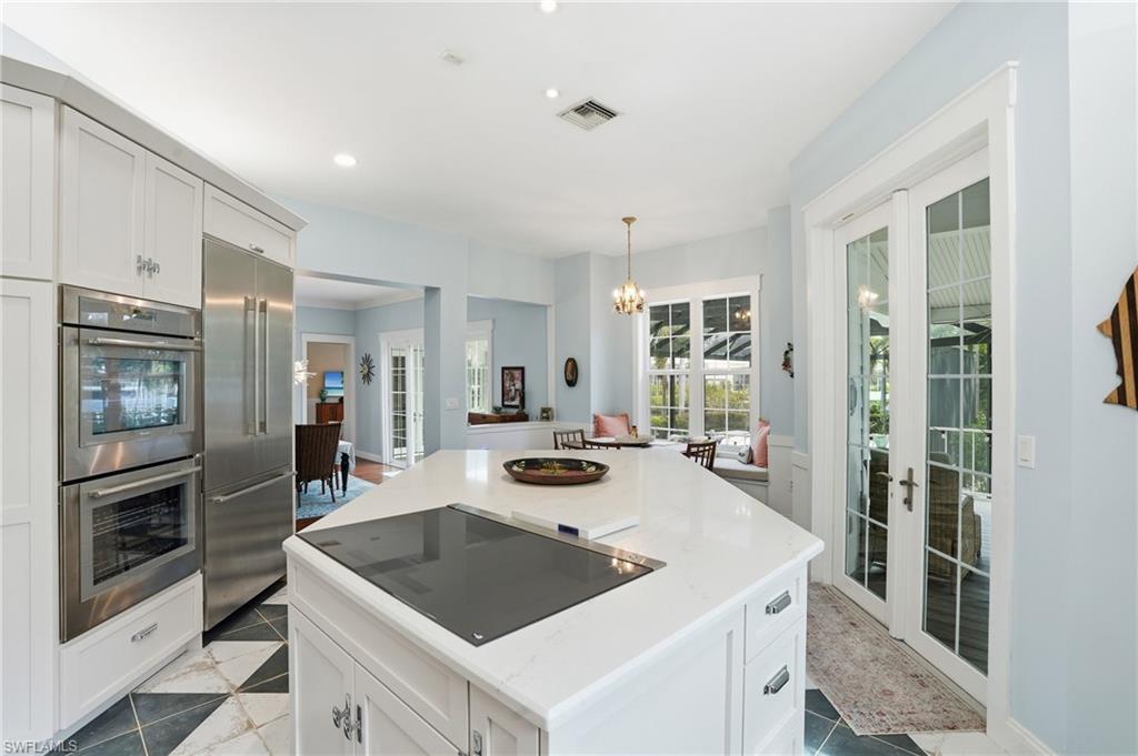 Kitchen with white cabinetry, french doors, a kitchen island, stainless steel appliances, and recessed lighting