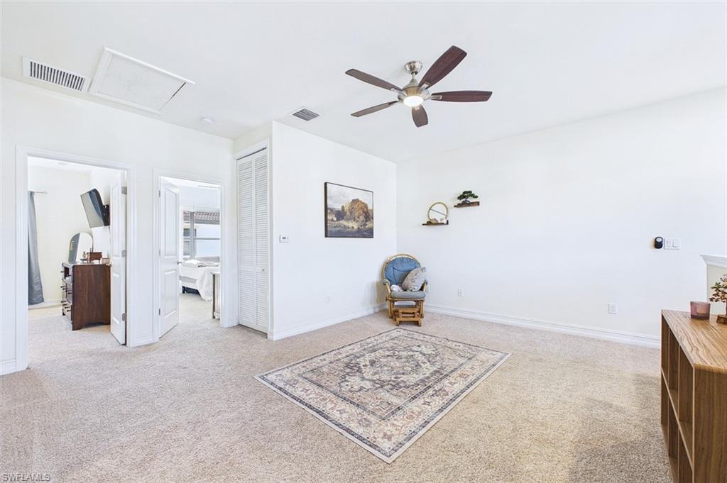 Living area with carpet flooring and ceiling fan