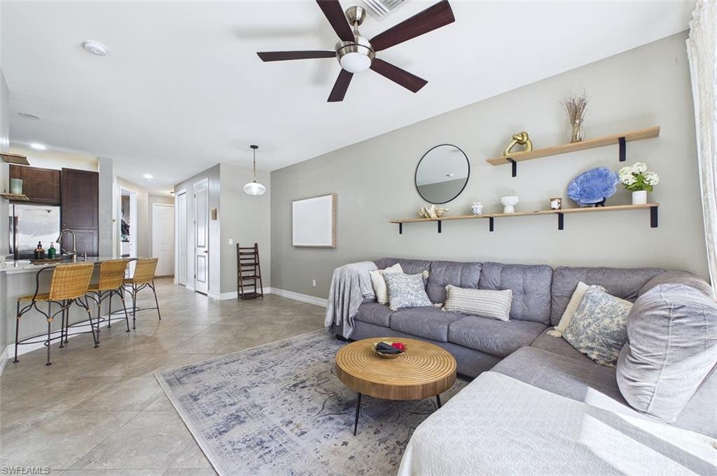 Living room with ceiling fan, recessed lighting, and light tile patterned floors