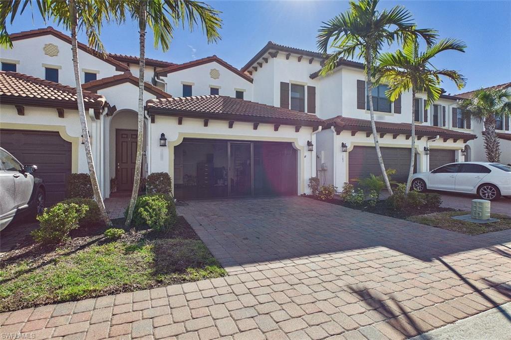 Mediterranean / spanish-style house with stucco siding, decorative driveway, and a tile roof