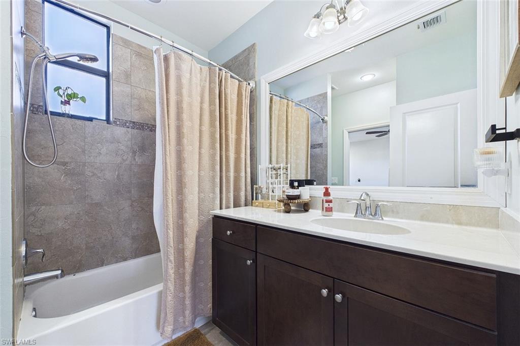 Full bath with shower / bath combo with shower curtain and vanity