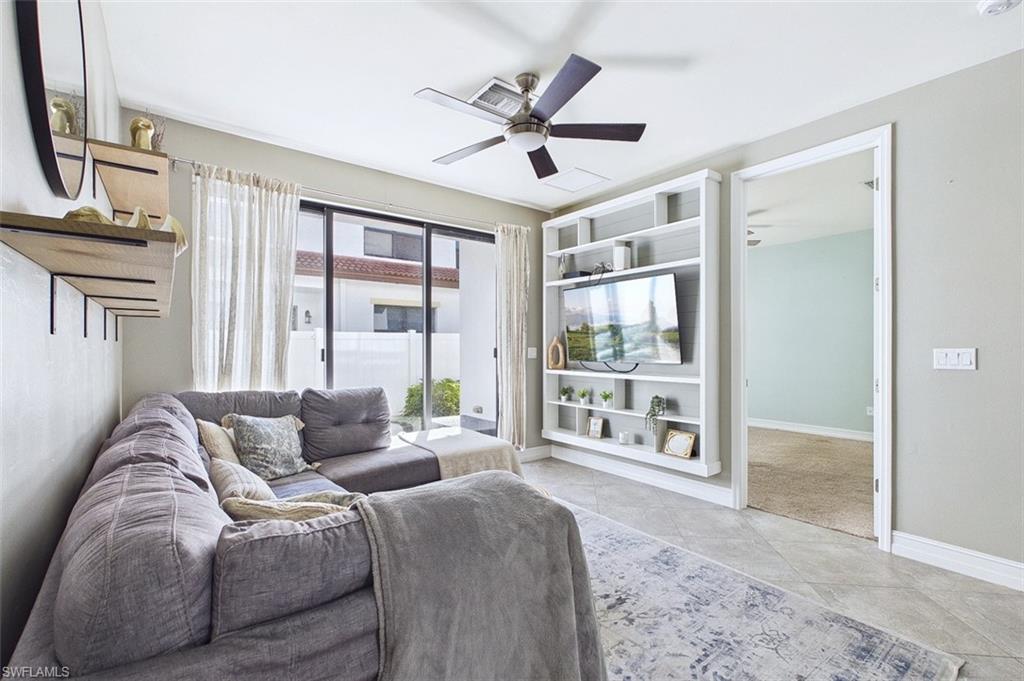 Living room featuring a ceiling fan and light tile patterned floors