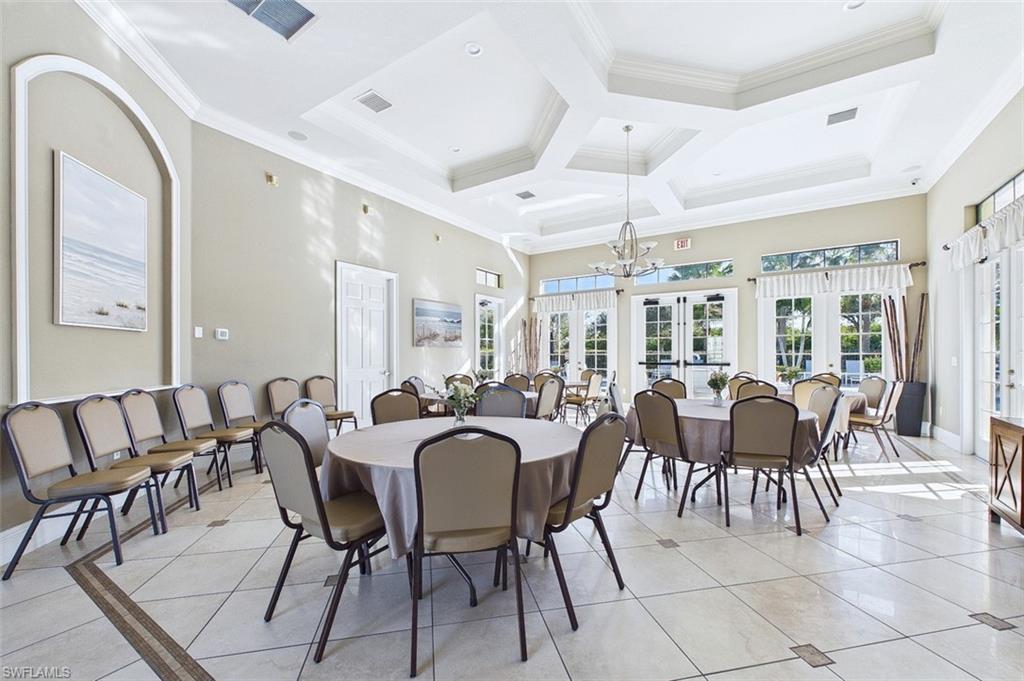 Dining room featuring light tile patterned floors, ornamental molding, french doors, coffered ceiling, and a towering ceiling