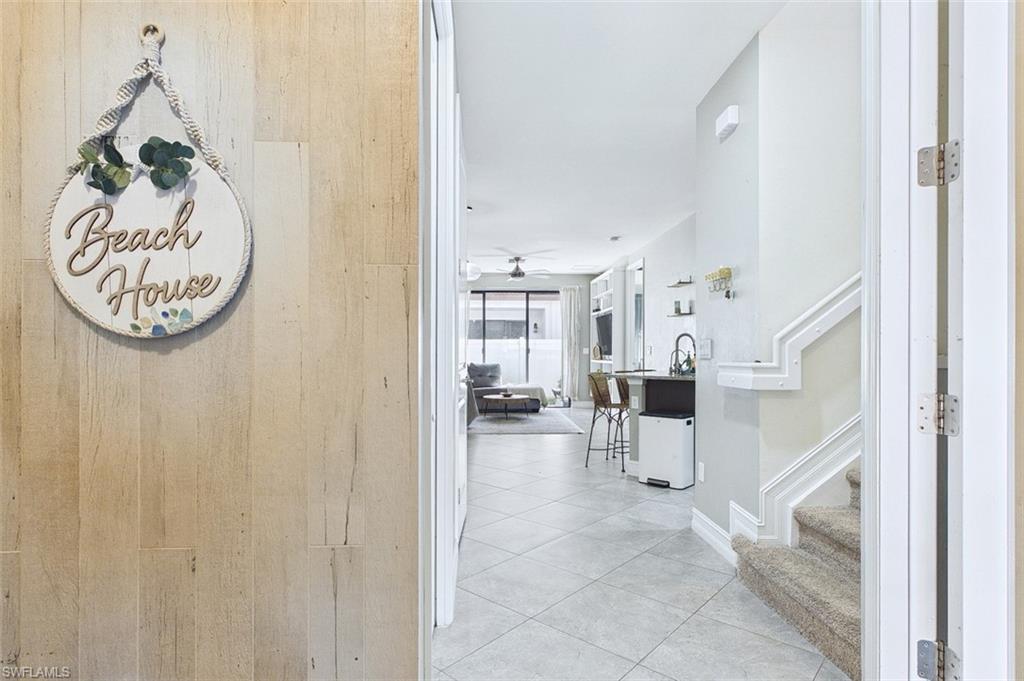 Hallway featuring stairway and light tile patterned flooring