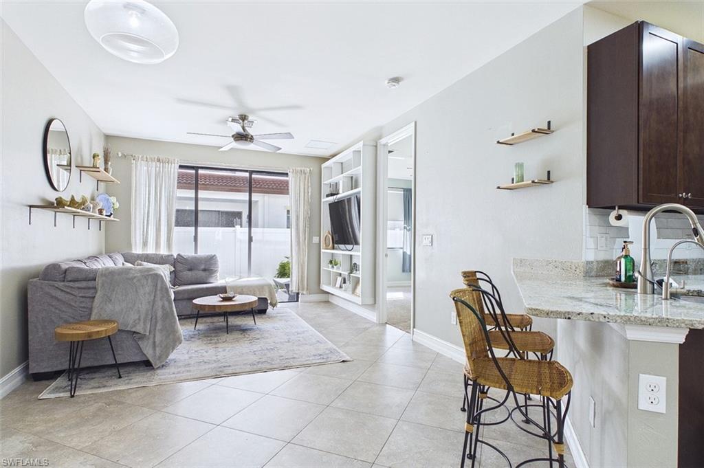 Living room featuring ceiling fan and light tile patterned floors