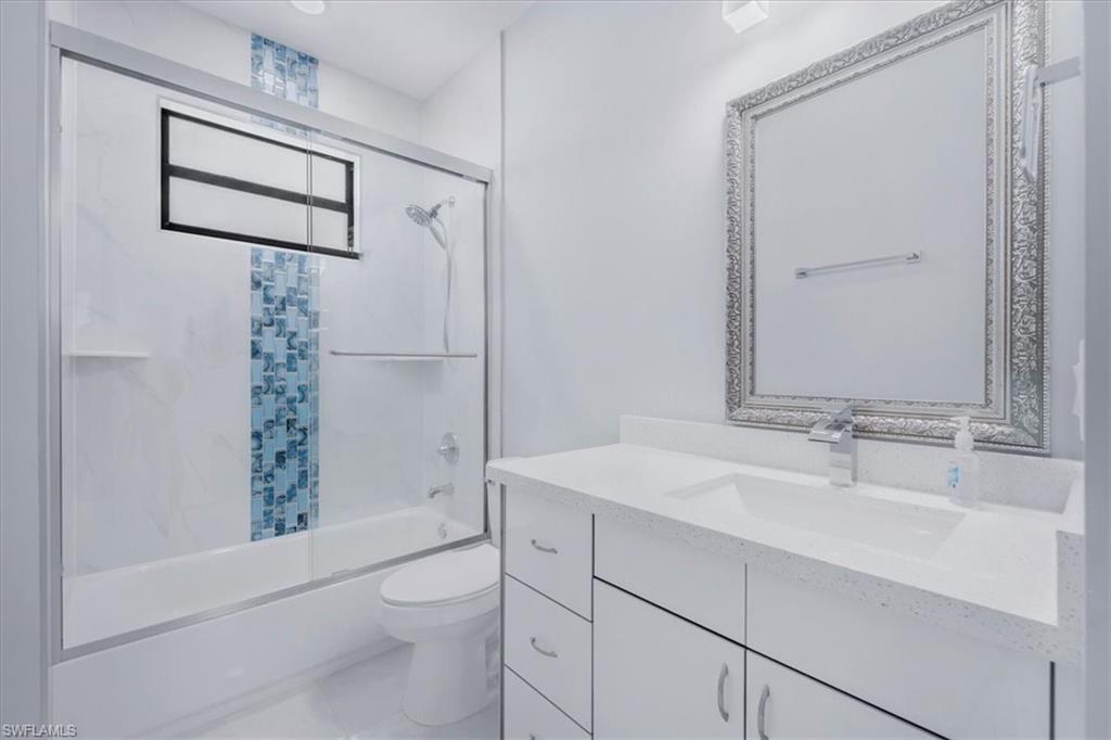 Bathroom featuring vanity and enclosed tub / shower combo
