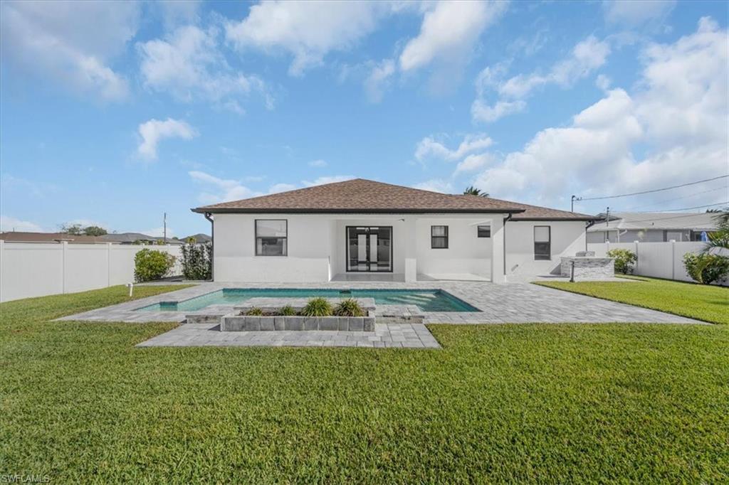 Back of property with stucco siding, a fenced backyard, and a patio