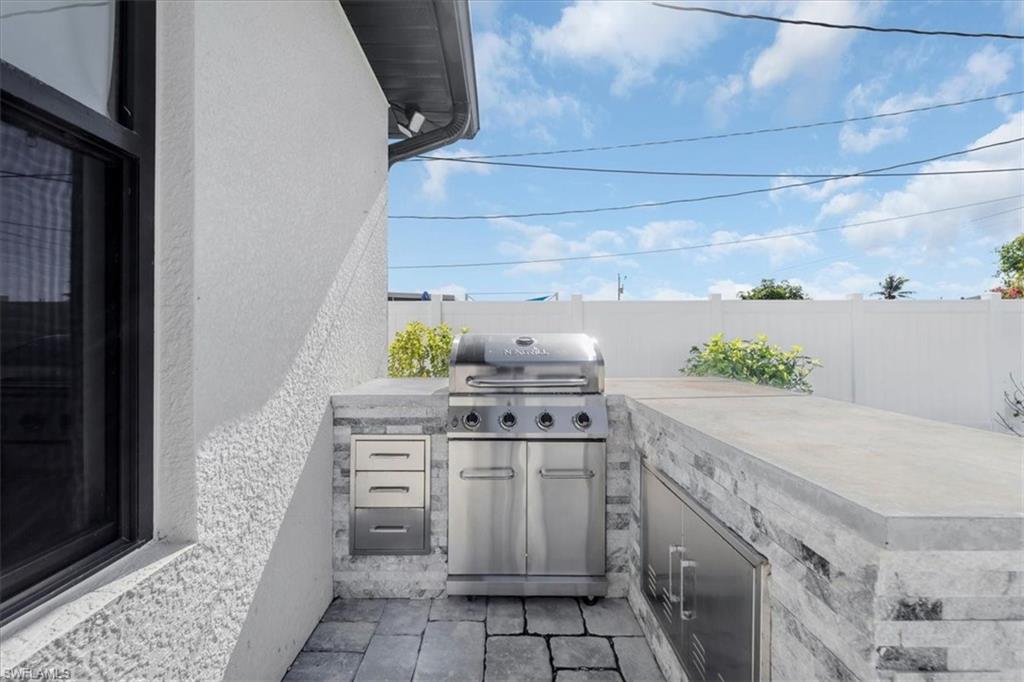 Fenced backyard featuring area for grilling and a patio