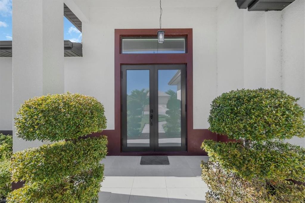 View of exterior entry featuring french doors and stucco siding