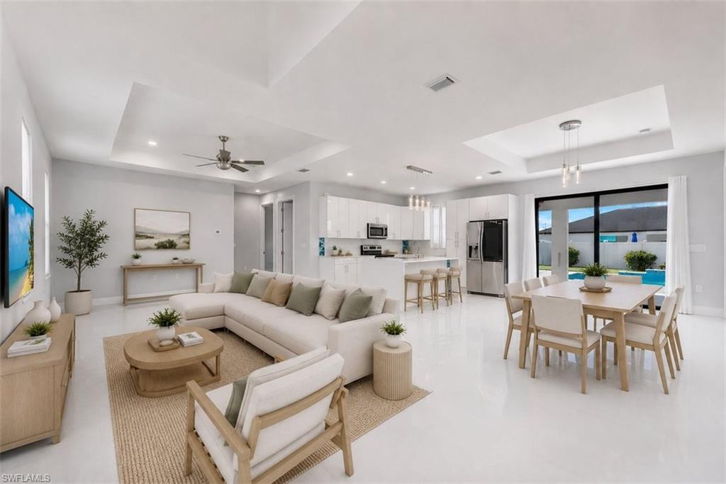Open-concept living space featuring high ceilings, recessed lighting, and white tile flooring
