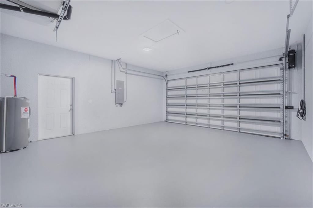 Garage featuring electric water heater and electric panel