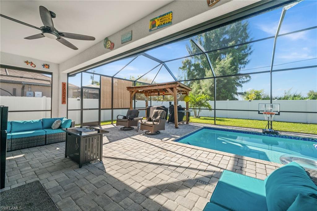View of pool with an outdoor living space with a fire pit, a lanai, a patio, and a sunroom