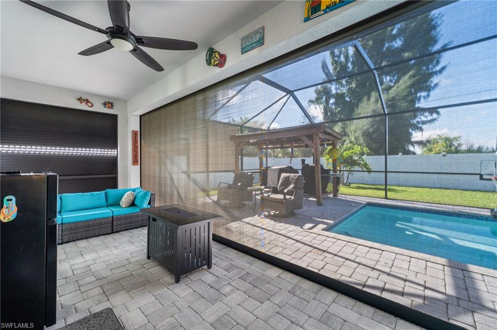 View of pool with an outdoor hangout area, glass enclosure, a patio, and a sunroom