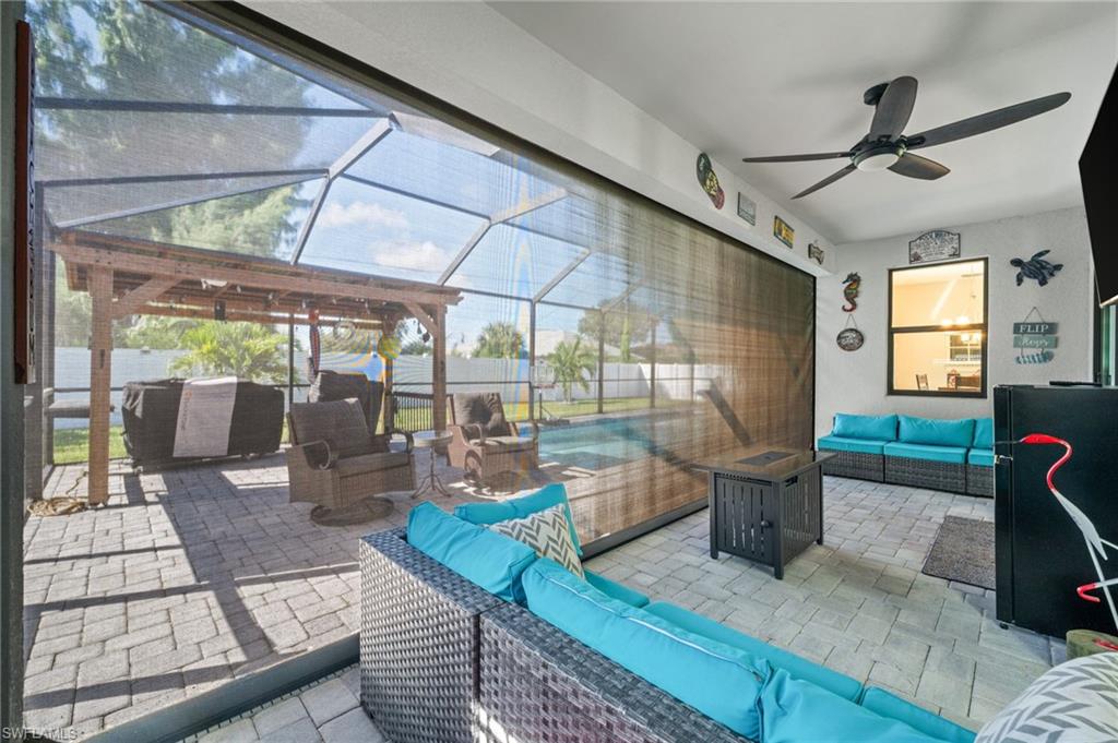 View of patio / terrace featuring an outdoor living space, a sunroom, glass enclosure, and a ceiling fan