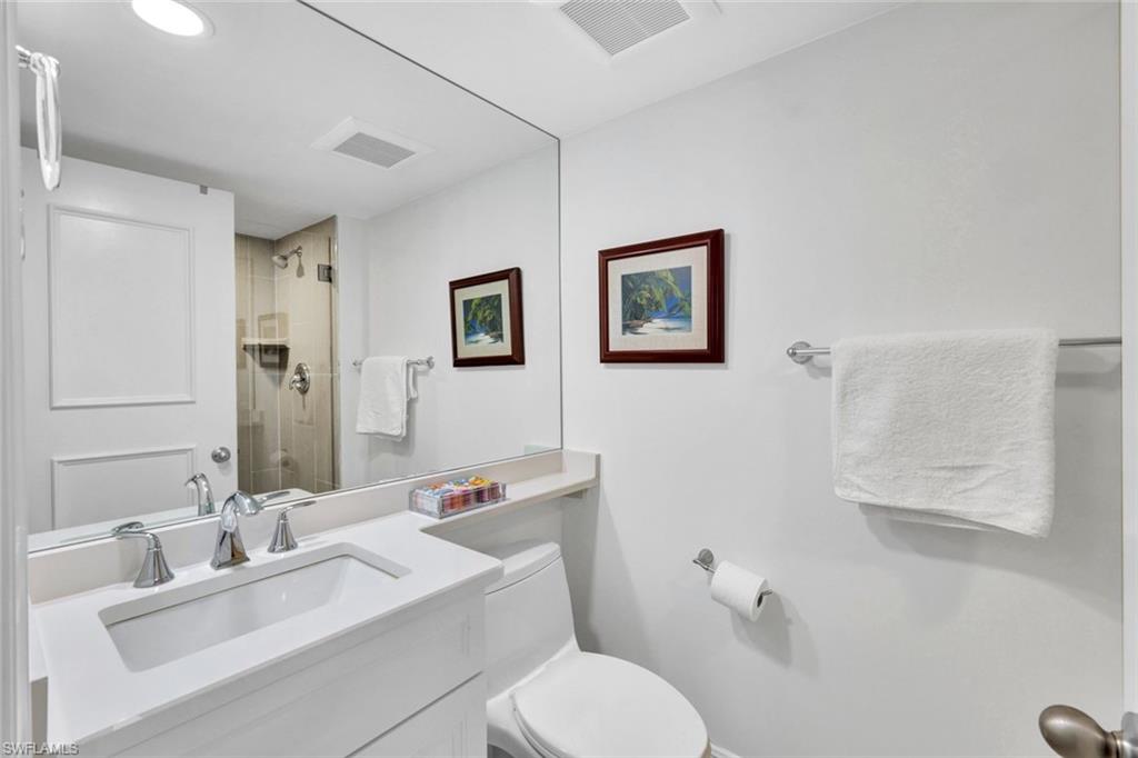 Bathroom with vanity, an enclosed shower, and toilet