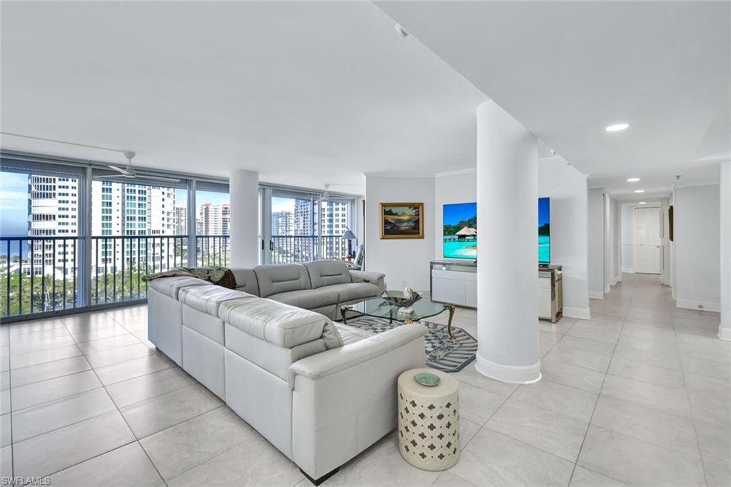 Tiled living room featuring ceiling fan and a wall of windows