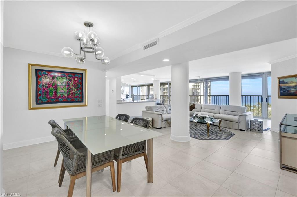 Dining space featuring crown molding, light tile patterned floors, and an inviting chandelier