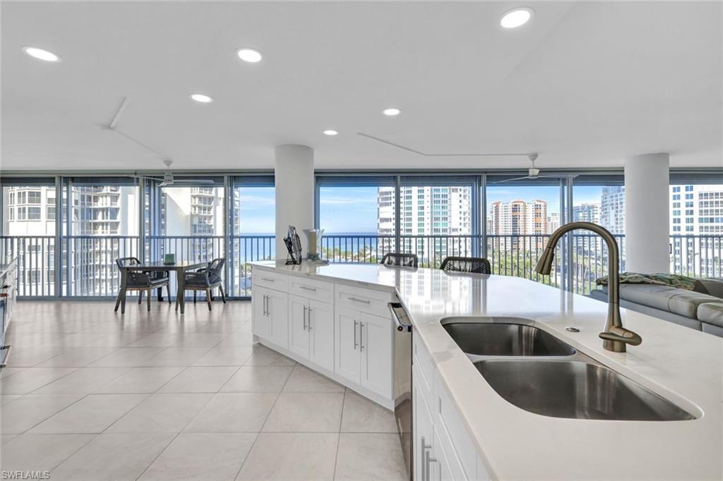 Kitchen with white cabinetry, sink, light tile patterned floors, and stainless steel dishwasher