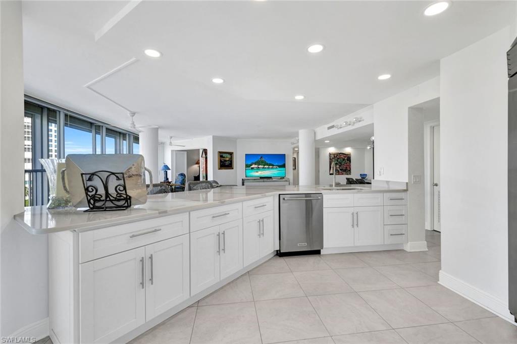 Kitchen with sink, dishwasher, ceiling fan, white cabinetry, and kitchen peninsula