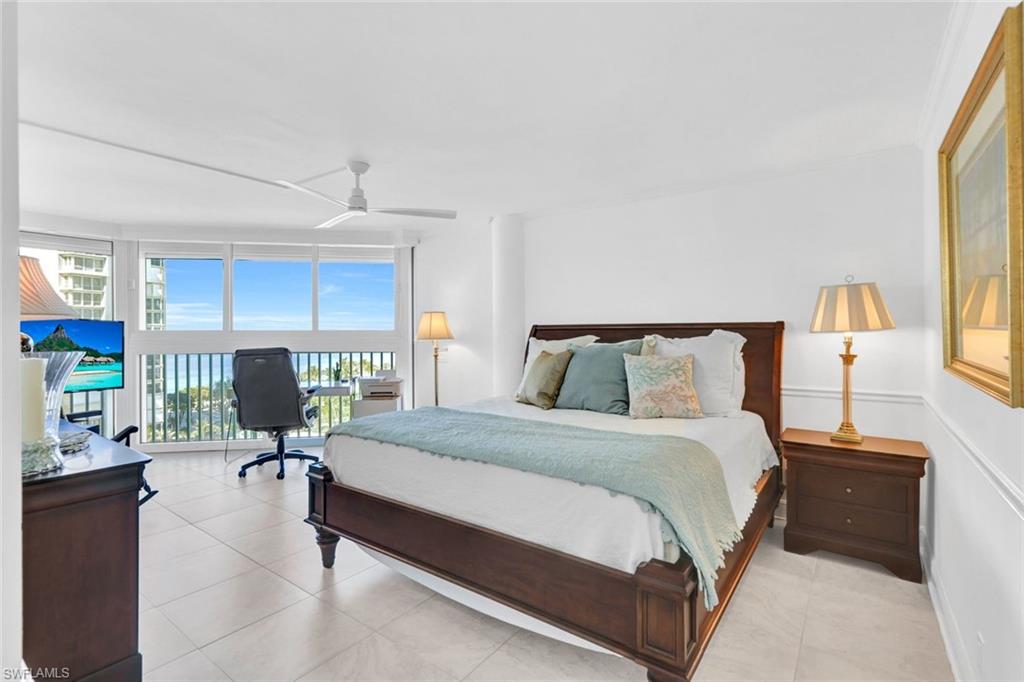 Bedroom with multiple windows, access to exterior, a wall of windows, and ceiling fan