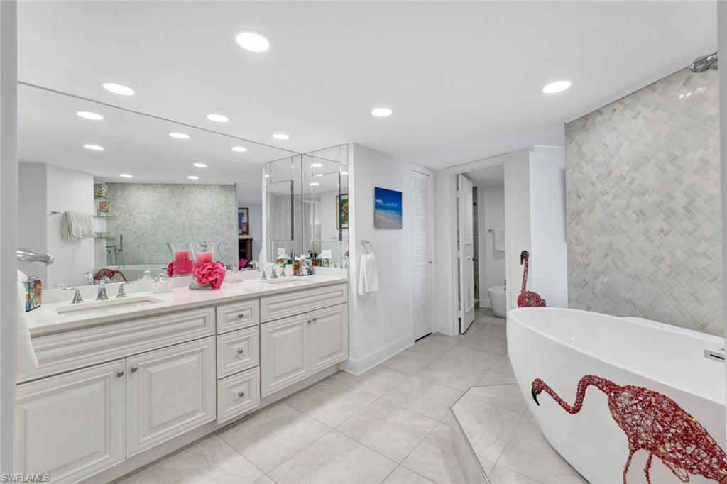 Full bathroom featuring independent shower and bath, vanity, tile patterned flooring, and toilet