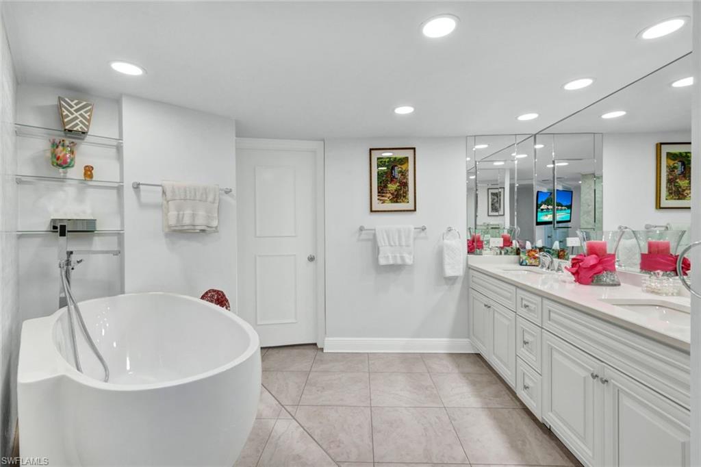 Bathroom with vanity, tile patterned flooring, and a bathing tub