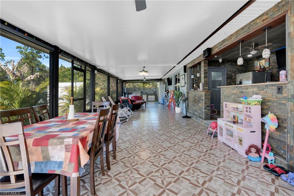 Sunroom with ceiling fan, outdoor dining space, and outdoor lounge area