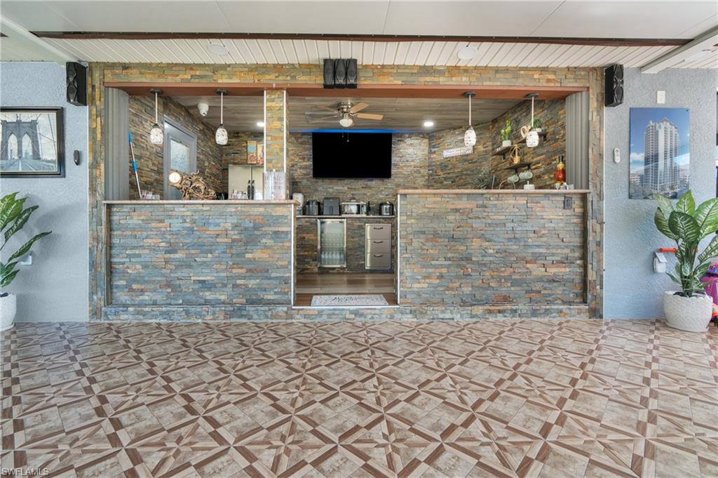Bar featuring a textured wall and a ceiling fan
