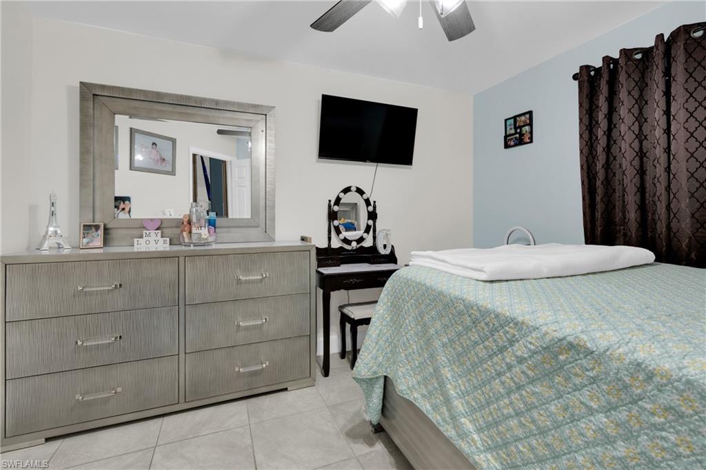 Bedroom with a ceiling fan and light tile patterned floors