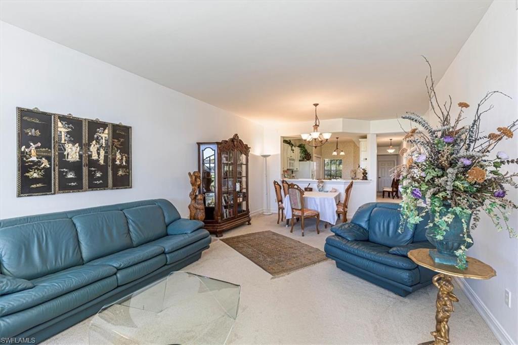 Living area featuring carpet and a chandelier