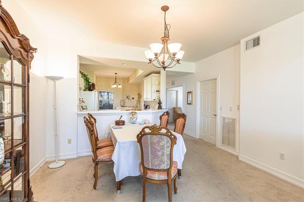 Dining room with a chandelier and light colored carpet