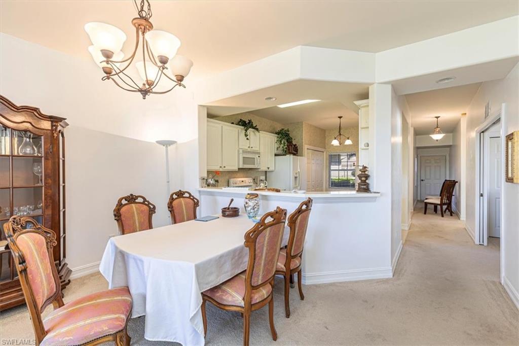 Dining space featuring a chandelier and light carpet