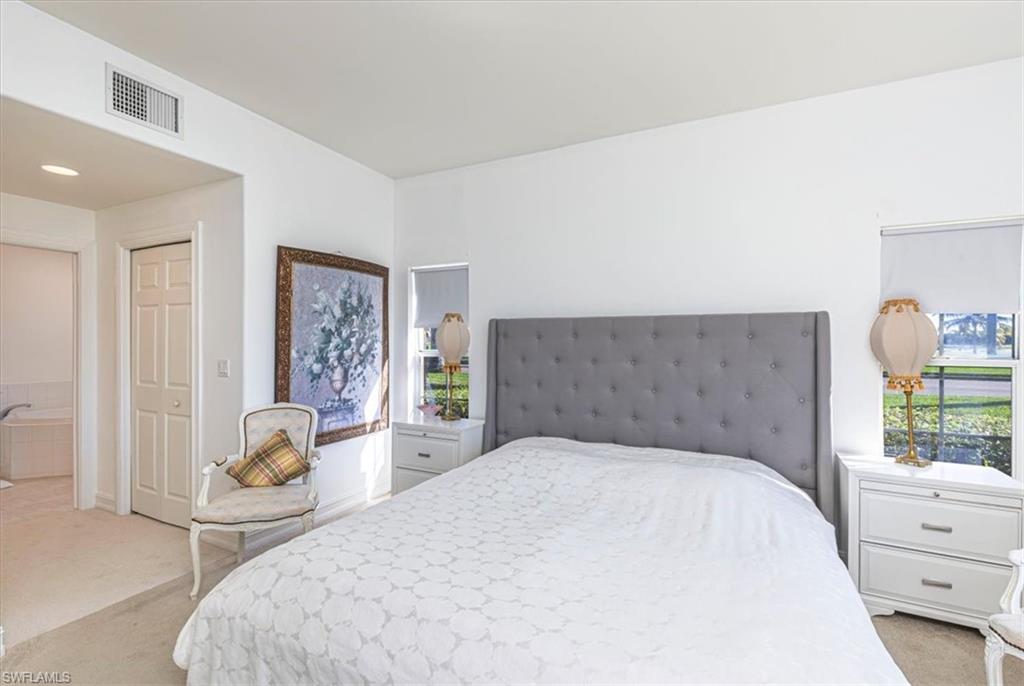 Bedroom with light carpet, multiple windows, and a closet