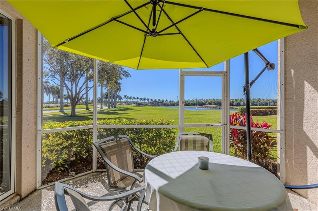 Sunroom with outdoor dining area, a water view, and golf course view