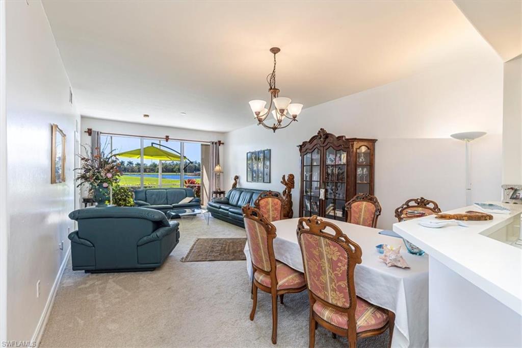 Dining area with light colored carpet and a chandelier